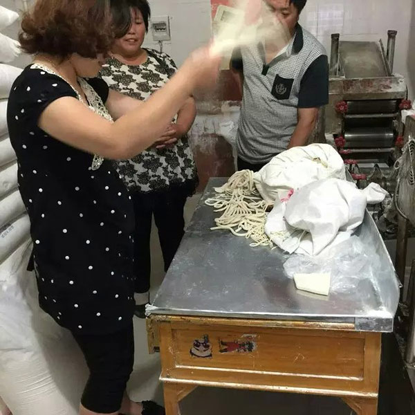 工作人員正在甩面,展示一品鮮面食的勁道程度